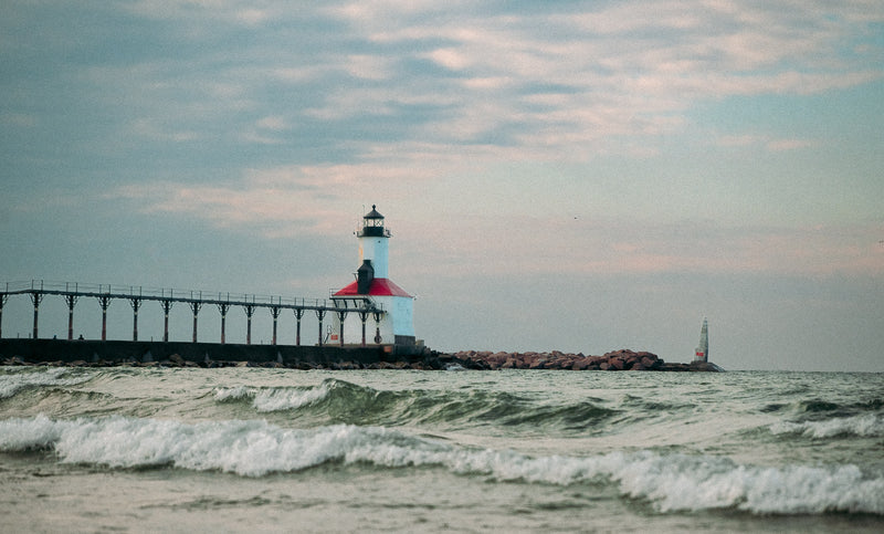 Michigan City Lighthouse on a pier with waves in the foreground